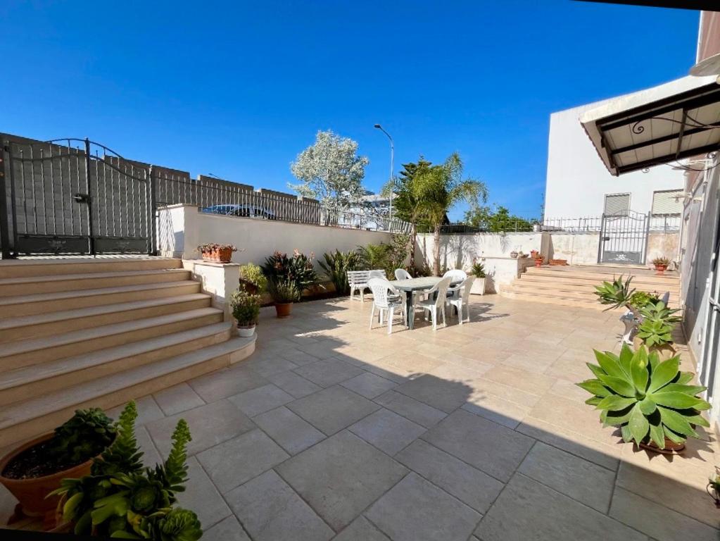 a patio with a table and chairs and stairs at Dimora Giovanna in Poggiardo