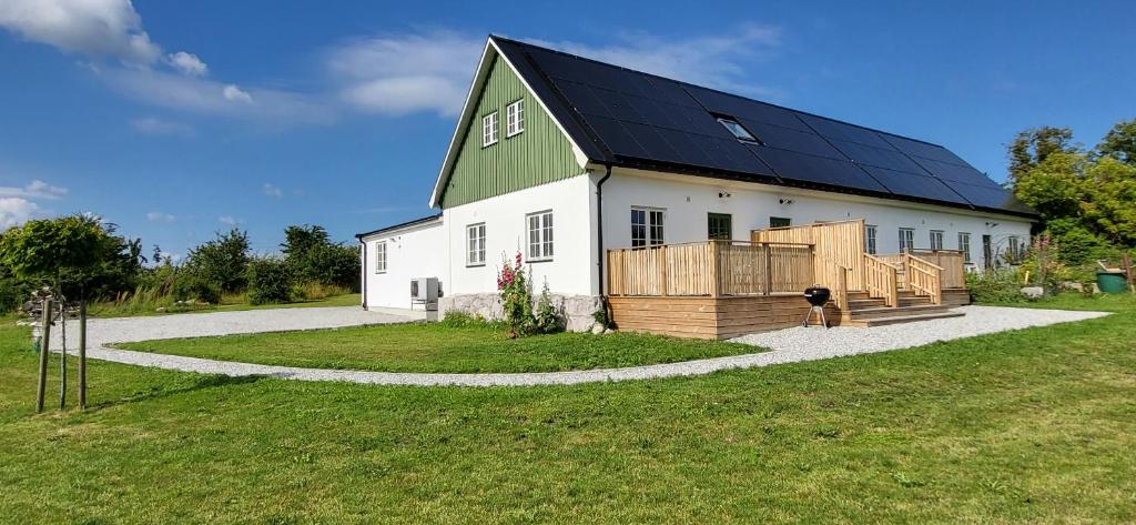 a large white barn with a green roof at Stora Beddinge - Moon apartment in Klagstorp