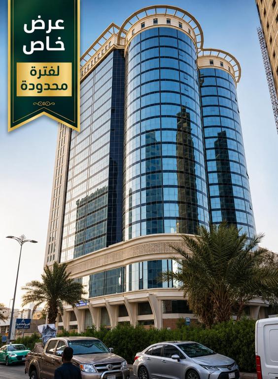 a large building with cars parked in front of it at فندق شعاع النزهة - مكة المكرمة in Mecca