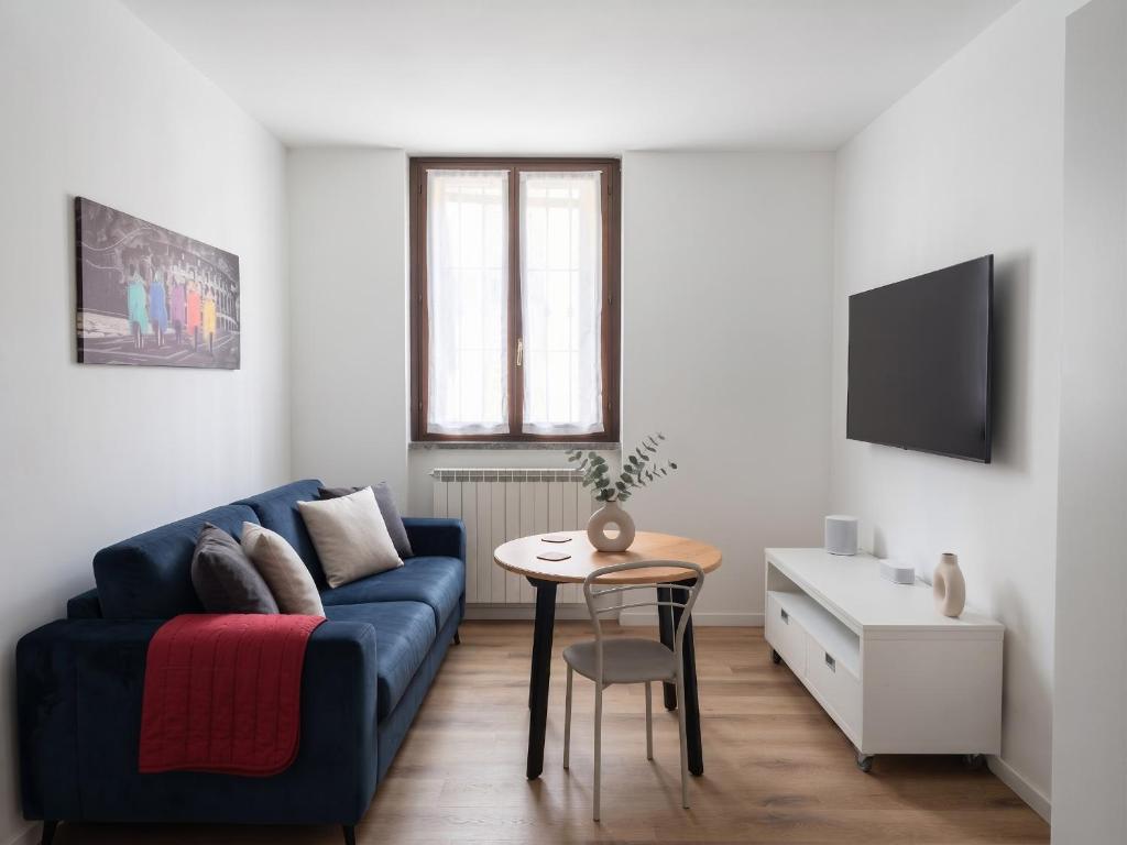 a living room with a blue couch and a table at Oasi Bernareggio Smart Work & Relax in Bernareggio
