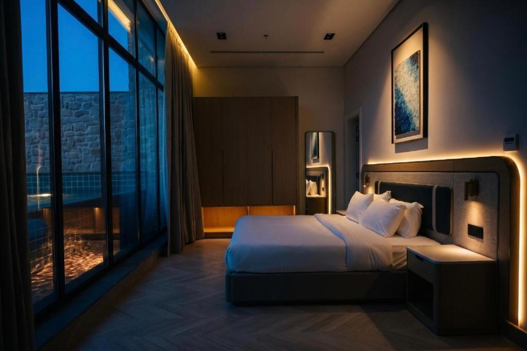 a bedroom with a large bed and a large window at V Beach in Jeddah