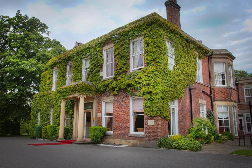 a building covered in ivy on a street at Farington Lodge Hotel in Preston