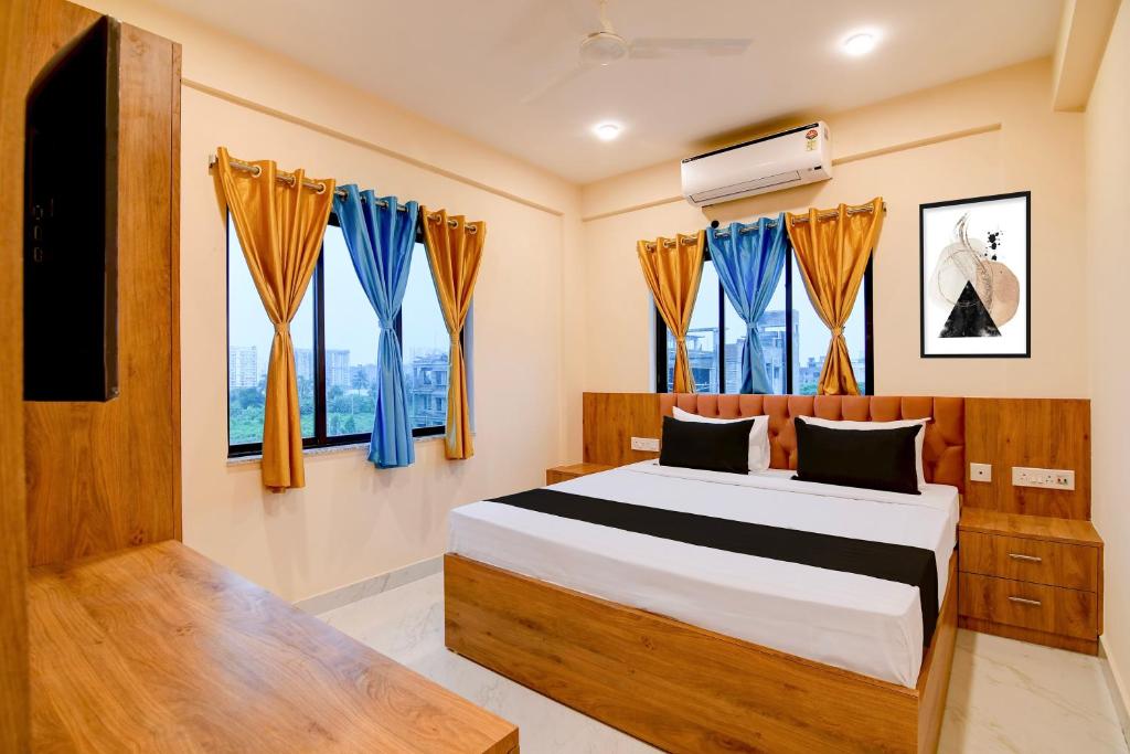 a bedroom with a bed with blue curtains at Hotel O NamaStay in kolkata