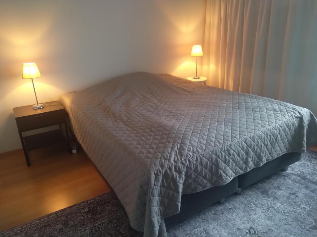a bedroom with a bed and two lamps on tables at Quiet room near everything in a shared apartment in Helsinki