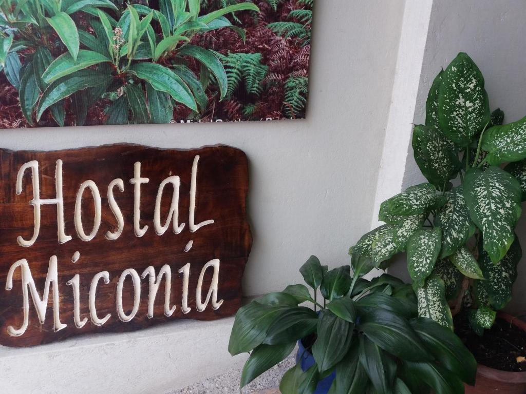 a sign that says hospital munciana next to plants at Hostal Miconia in Puerto Ayora