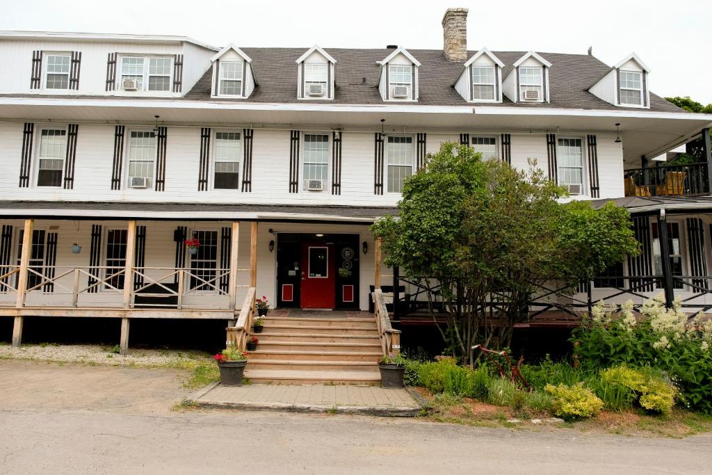 a large white house with a red door at Manoir Charlevoix in La Malbaie