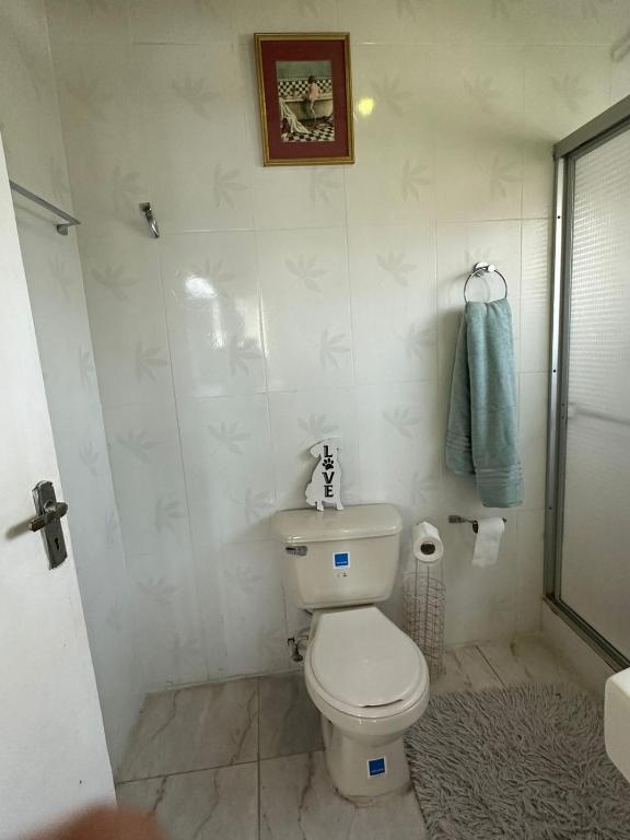 a bathroom with a toilet and a towel on the wall at Elite stays in Santa Cruz