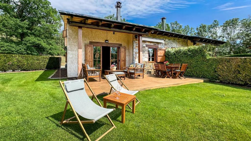 a patio with chairs and a table on a lawn at La Maison du Fleuve in Ur
