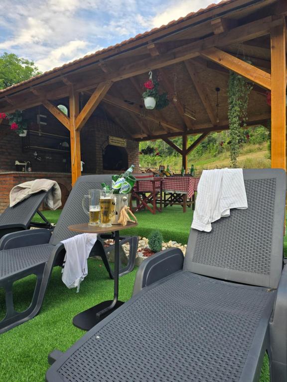a patio with chairs and a table with drinks on it at Kmetova Bajka in Janja