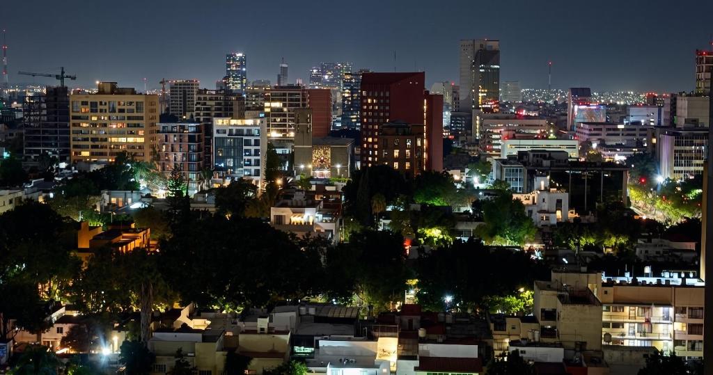 a view of a city at night with lights at Departamento de lujo en Col Americana con alberca in Guadalajara