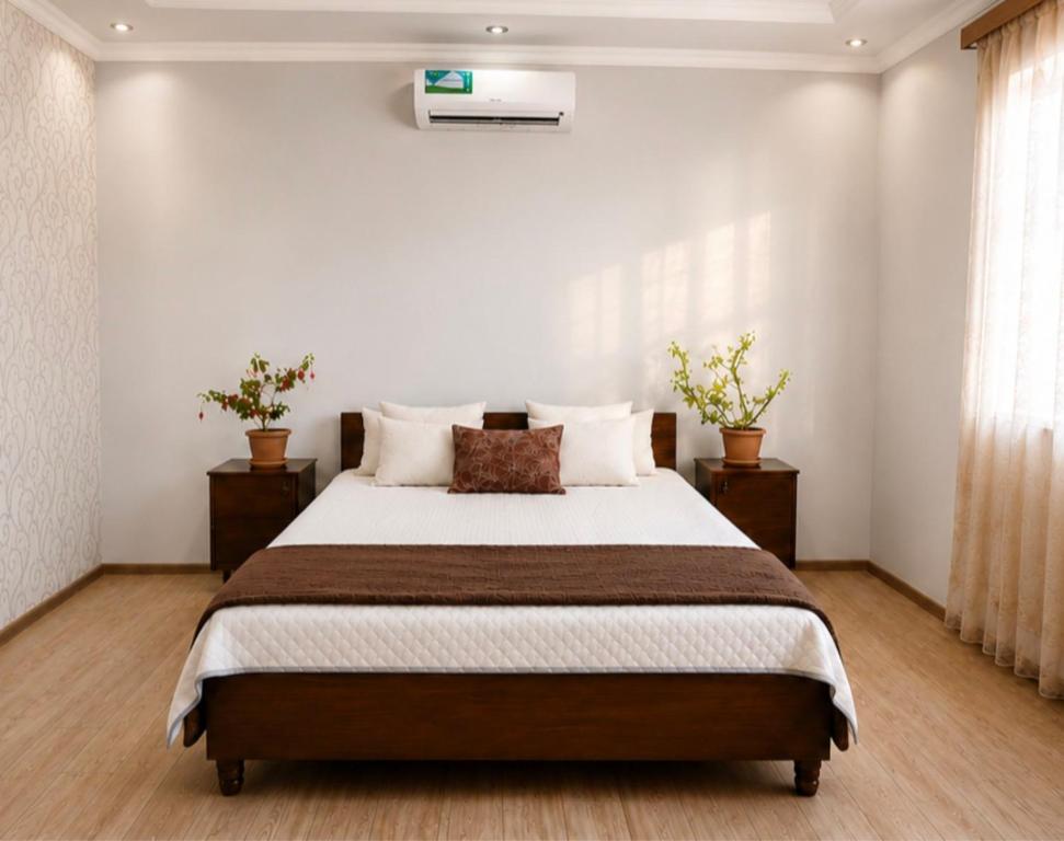 a bedroom with a large bed with two night stands at PIT STOP B&B Guesthouse in Urtsʼadzor