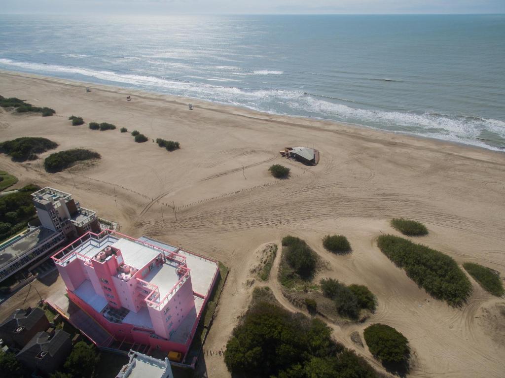 una vista aérea de una playa con un edificio y un coche en Sul Mare Hotel en Valeria del Mar