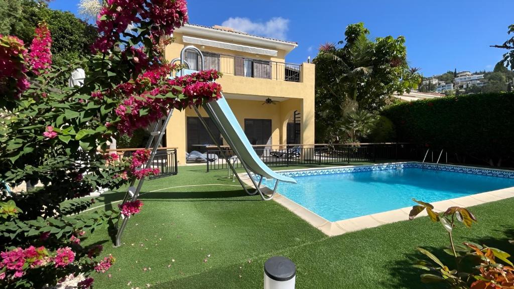 a house with a slide in front of a swimming pool at Luxury 3Bedroom Villa with Pool, Garden & Sunset in Tala