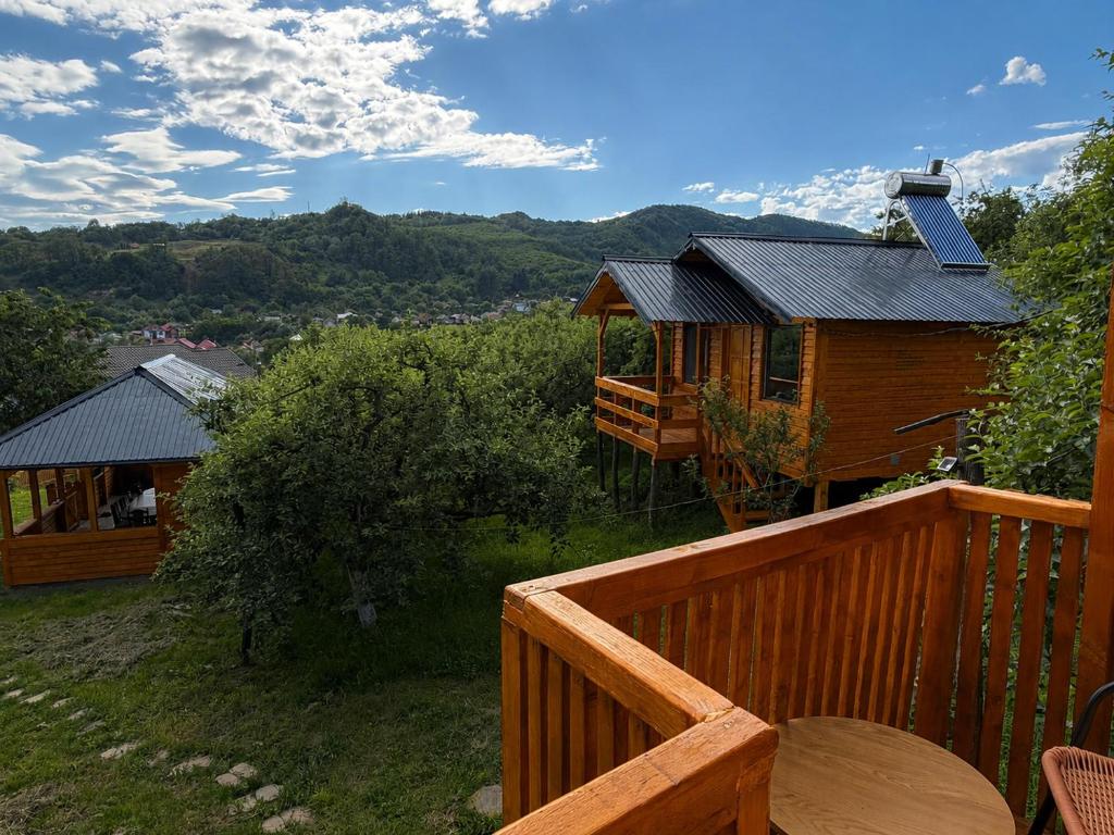 a cabin on a deck with a view of the mountains at Cabanele din livadă in Corbi