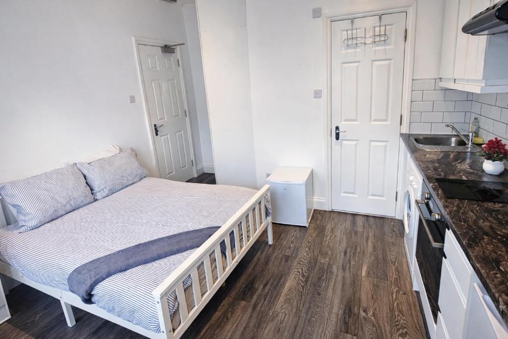 a small bedroom with a bed in a kitchen at Studio Flat London in The Hyde