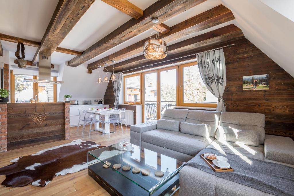 uma sala de estar com um sofá e uma mesa em Apartamenty Polana Sywarne Zakopane em Kościelisko