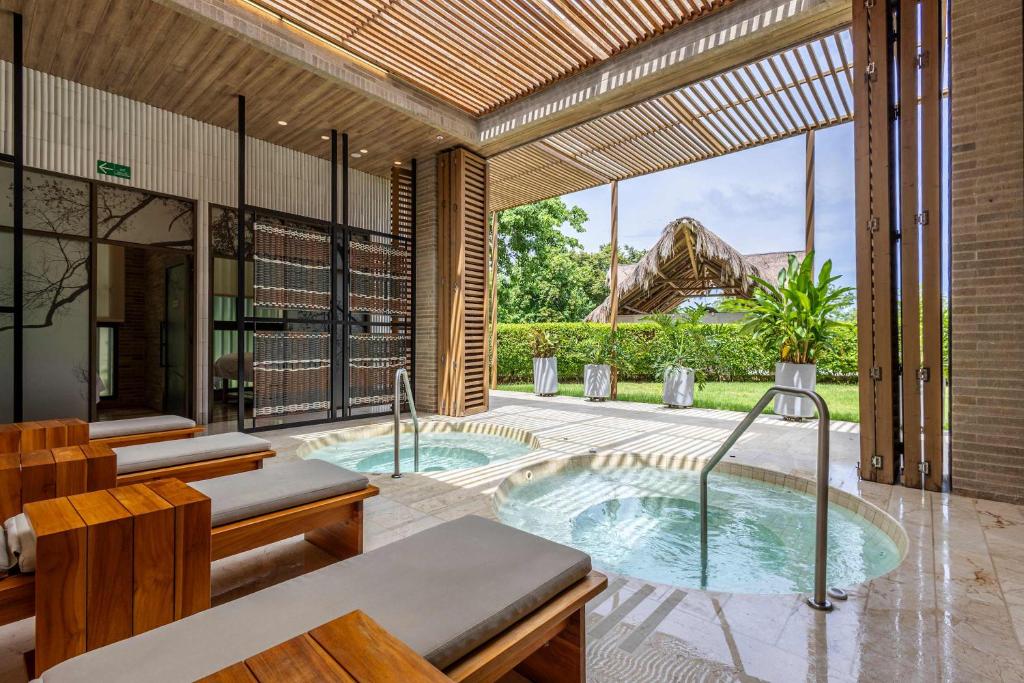an indoor pool with a hot tub in a house at 3 Bedroom apt with jacuzzi in Baru in Cartagena de Indias