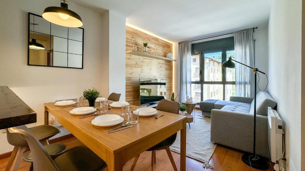 a kitchen and living room with a wooden table and a living room at Molina Molinísimo in La Molina