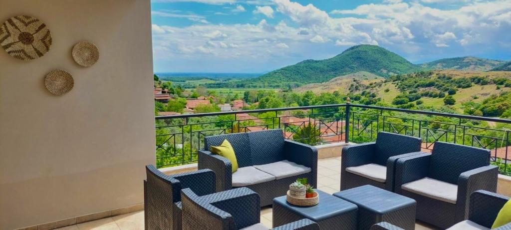 a balcony with chairs and a view of mountains at "LaGo Village House" Family & Group Retreat near Meteora in Kalabaka