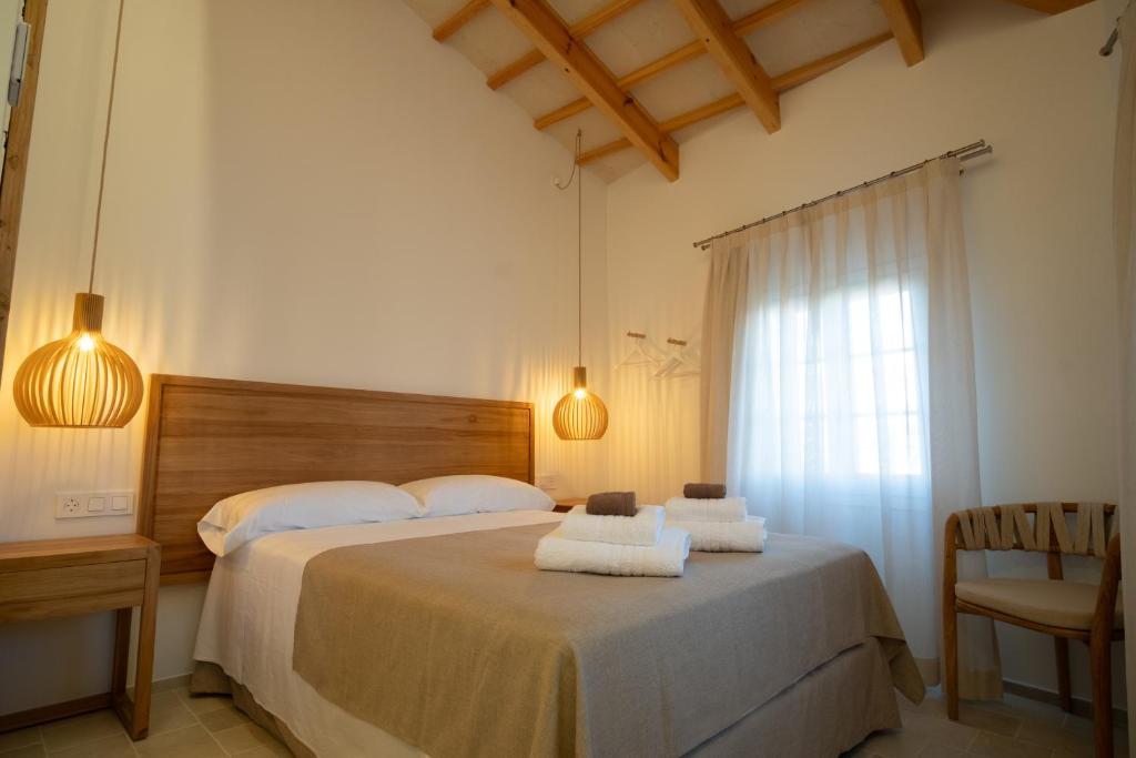 a bedroom with a bed with towels on it at Hotel Cas Ferrer Monjo in Ciutadella