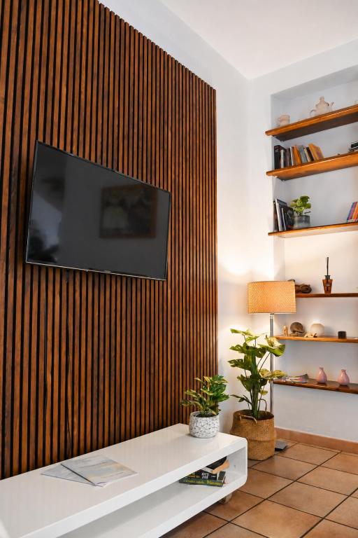 a living room with a television on a wooden wall at CASA MILENA in Settimo San Pietro
