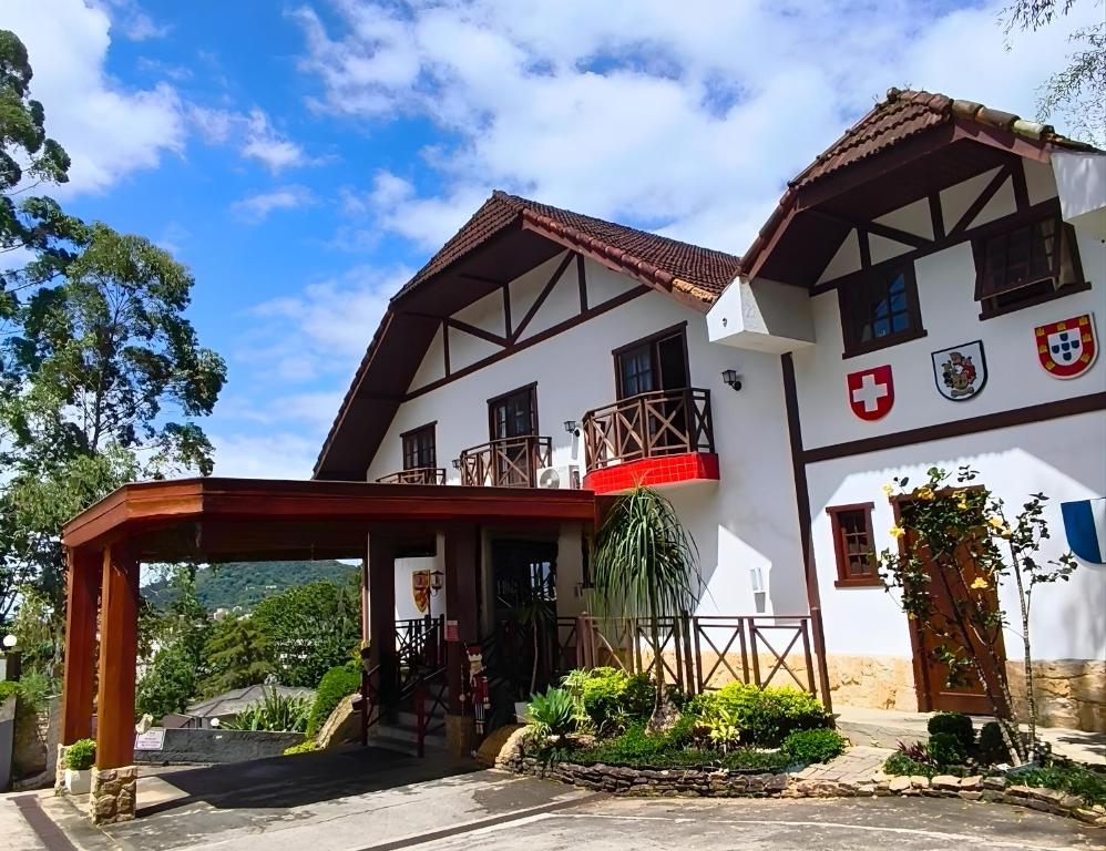 ein großes weißes Gebäude mit einem roten Balkon in der Unterkunft Hotel Willisau in Teresópolis