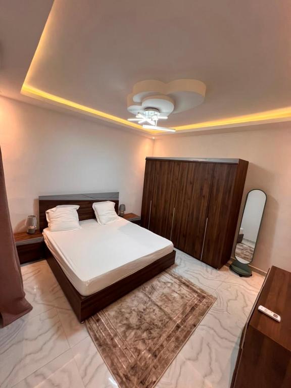 a bedroom with a large bed and a mirror at Residence LOUNA in Dakar
