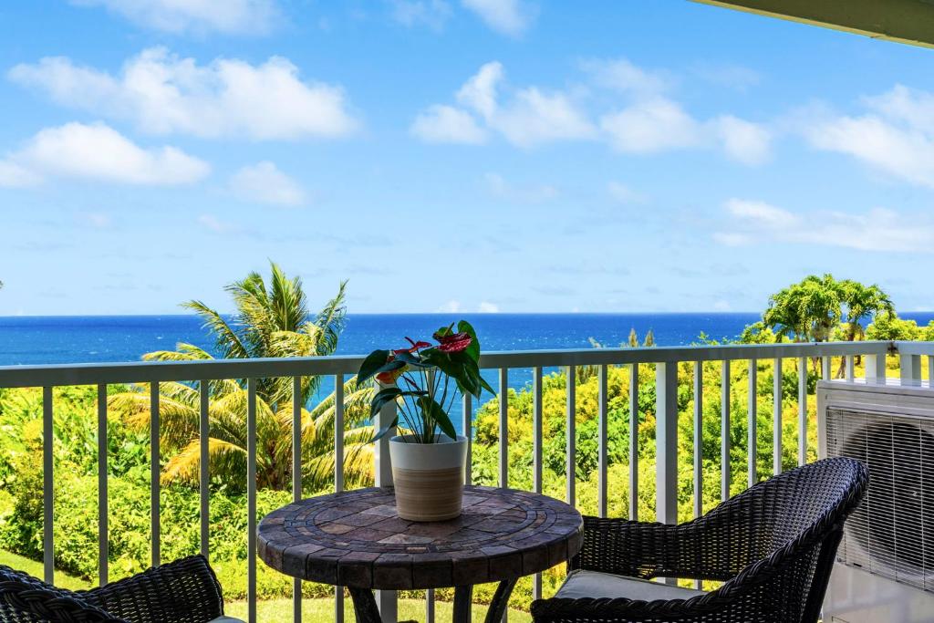 a table with a plant on a balcony with the ocean at Alii Kai 7201 in Princeville