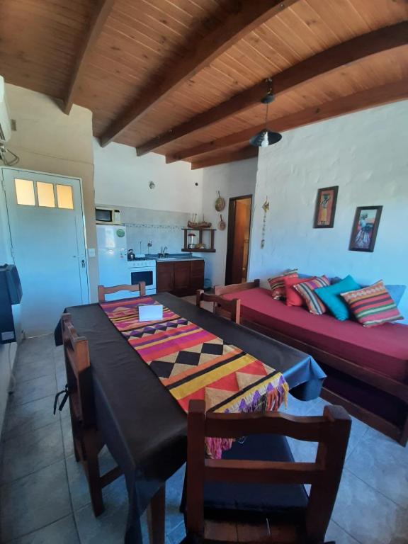 a room with two beds and a table and chairs at Dpto playa in Las Grutas