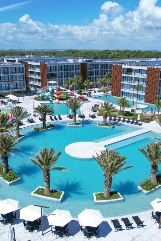 an overhead view of a large swimming pool with palm trees at Porto de Galinhas, Muro alto - PÉ NA AREIA in Ipojuca