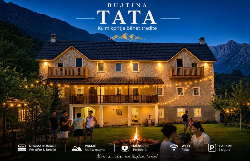 a group of people standing in front of a house with lights at Bujtina Tata in Curraj