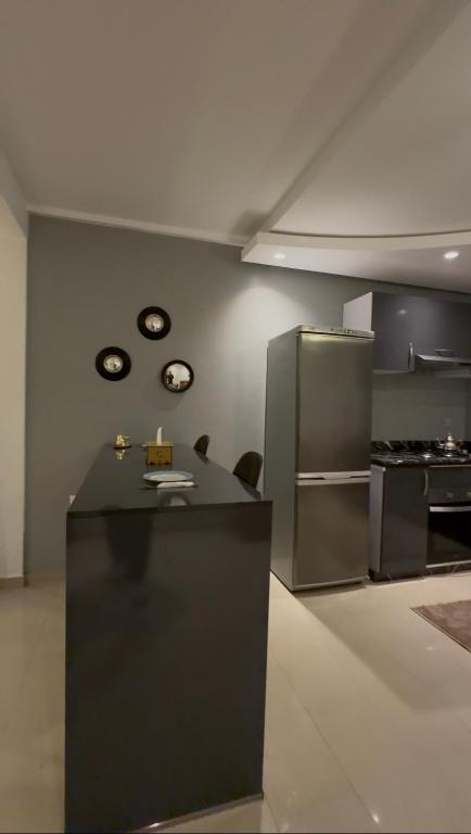 a kitchen with a black counter and a refrigerator at nouhaila Lag in Rabat