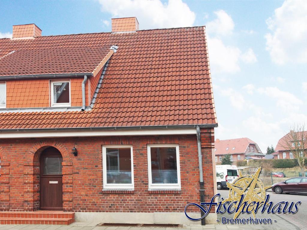 une maison en briques rouges avec un toit rouge dans l'établissement Fischerhaus Bremerhaven, à Bremerhaven