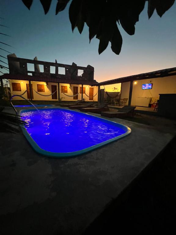 a blue swimming pool in the middle of a house at Suíte Adam 1 em Caraíva com piscina 900m da Vila in Caraíva