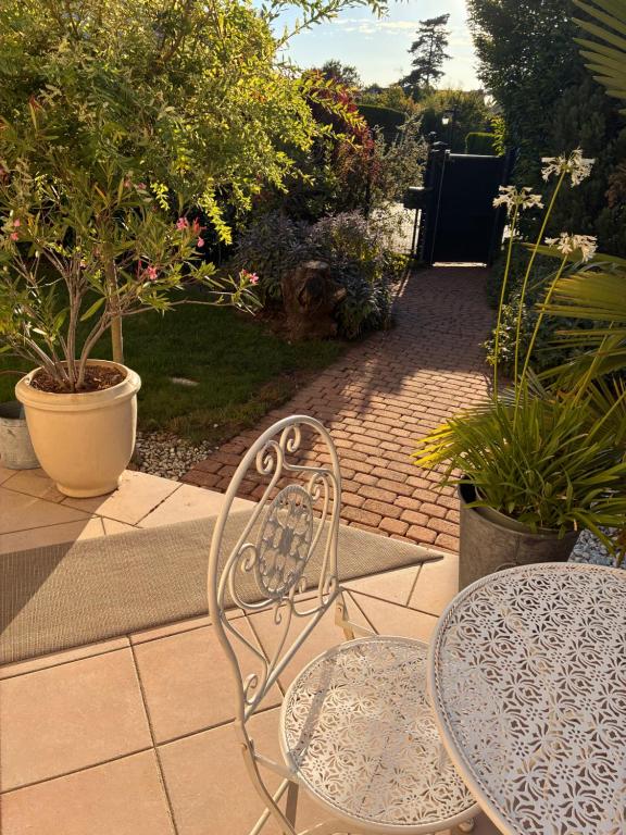 a patio with a table and a table and chairs at Orée de Villevert in Senlis