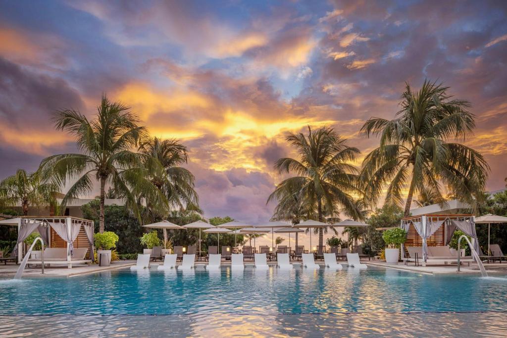 a rendering of a resort pool with chairs and palm trees at Alaia Belize, Autograph Collection in San Pedro
