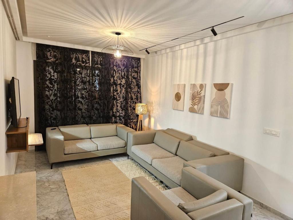 a living room with two couches and a tv at Casa marsa in Gammarth