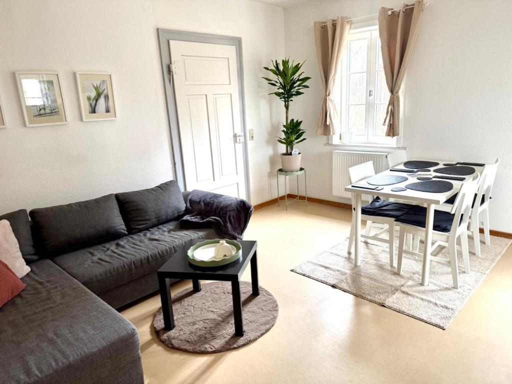 a living room with a couch and a table at Süße Wohnung im Grünen in Weiler