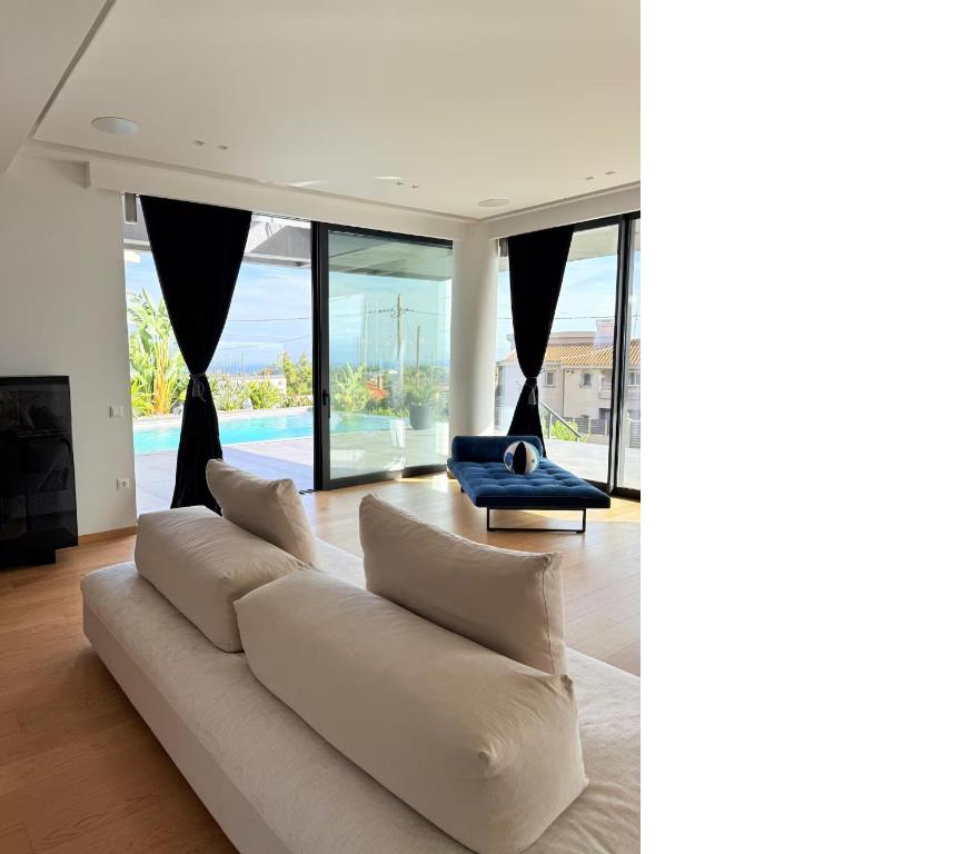a living room with a white couch and a blue chair at Wiile State in Athánatoi
