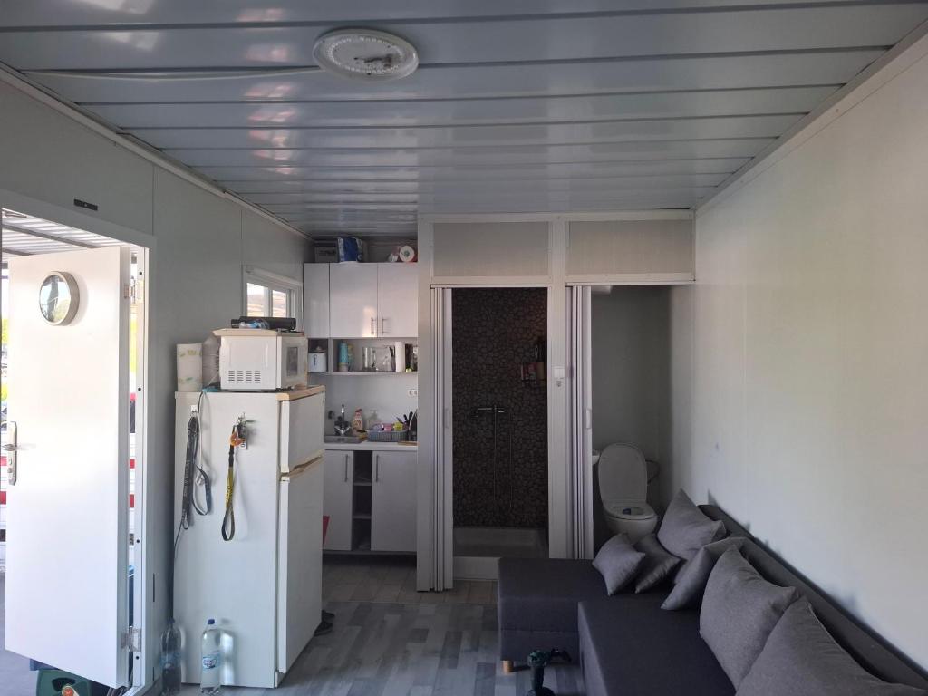 a living room with a couch and a refrigerator at Cuki Apartmanház in Sarud
