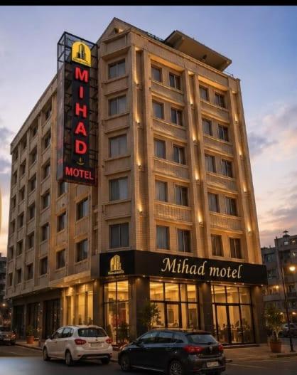 a hotel with two cars parked in front of it at Hotel Mihad sulaymaniyah in As Sulaymānīyah