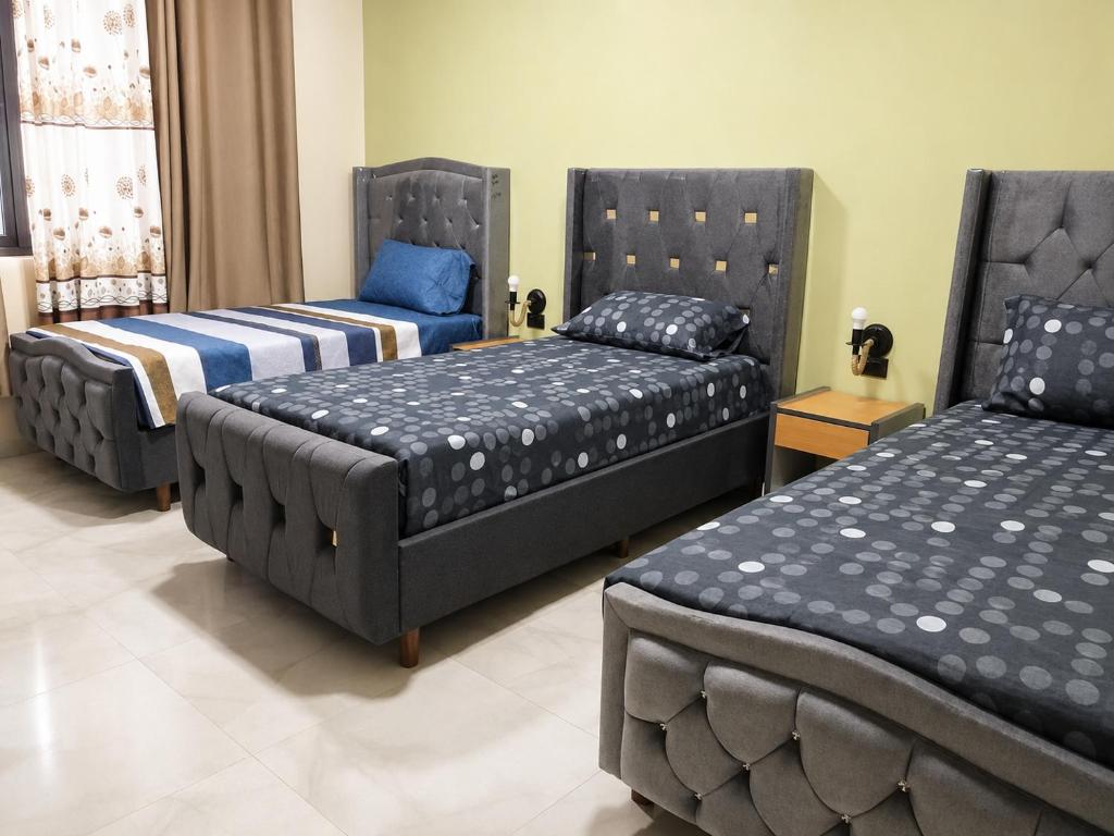 a room with three beds and a bed and a couch at Florida Palace Hostal in Samaipata