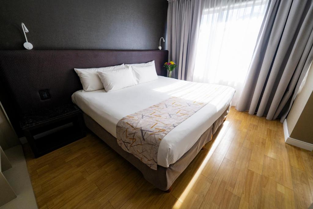 a bedroom with a large bed with a window at Amérian Córdoba in Córdoba
