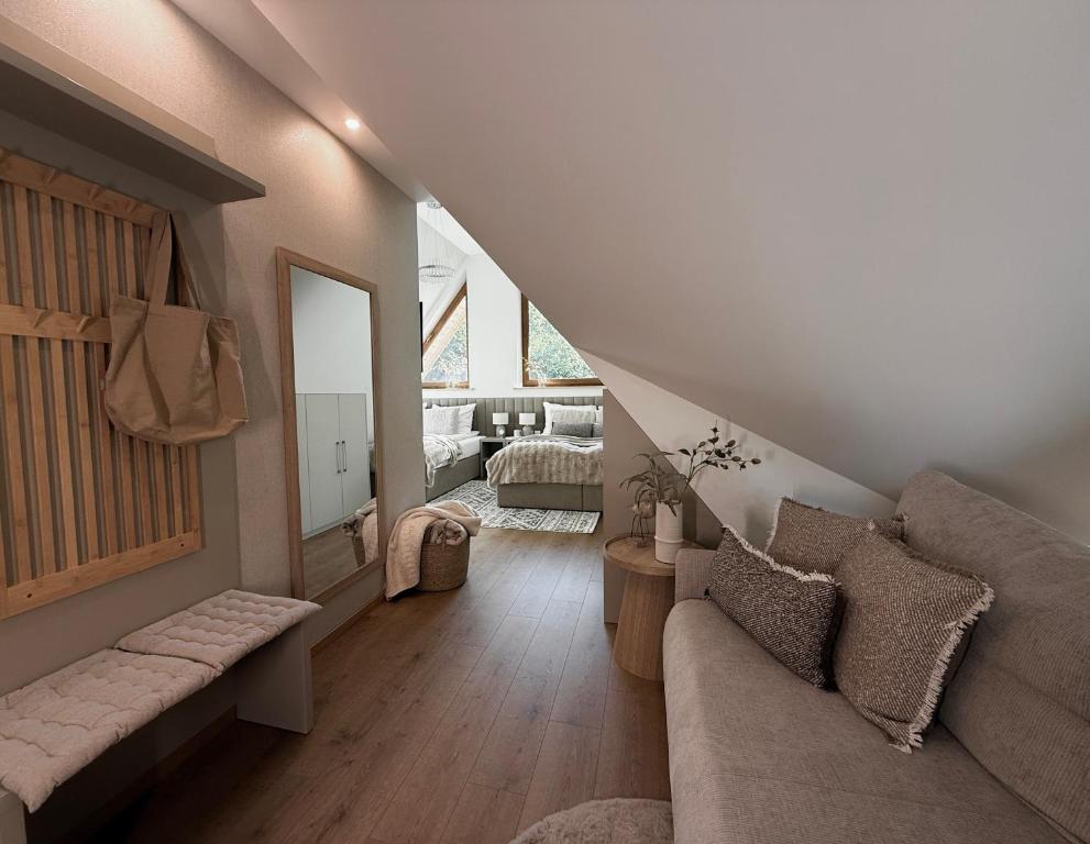 a living room with a couch and a mirror at Zacisze pod Tatrami in Suche