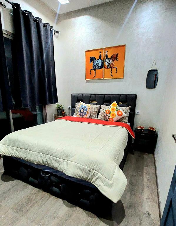 a bedroom with a large bed in a room at Appart Ennakhil 4 avenue mohamed 6 in El Jadida