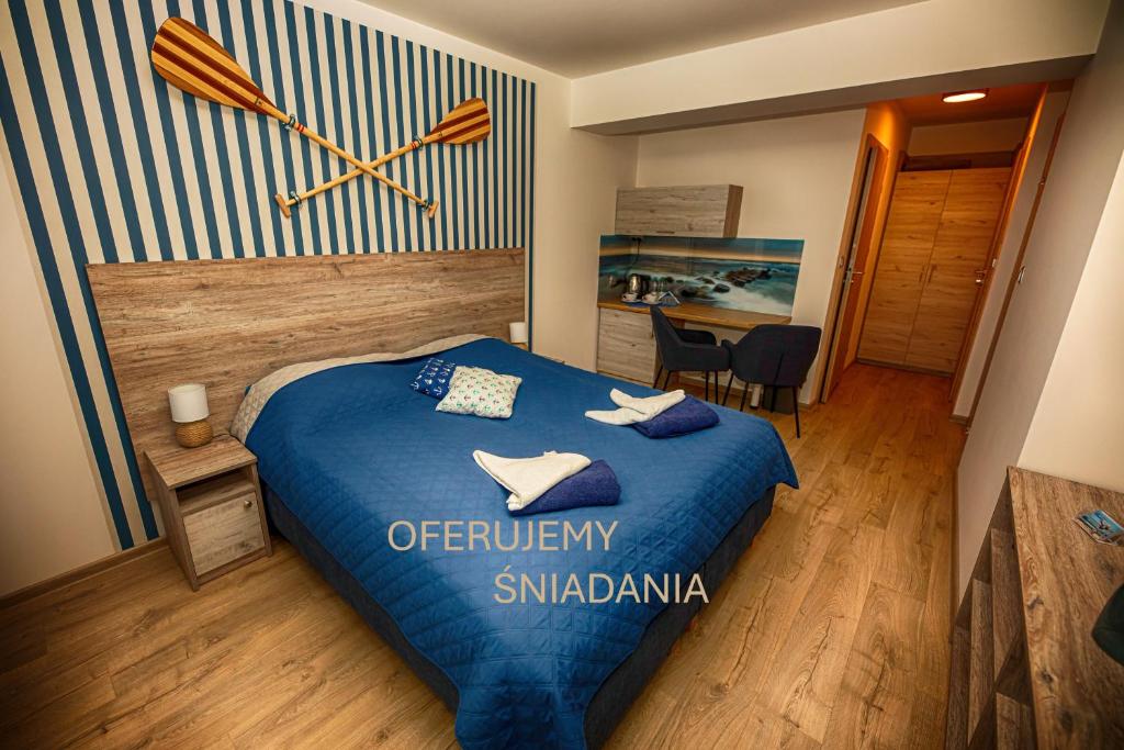 a bedroom with a blue bed with a paddle on the wall at Dom Wypoczynkowy ANNA - pobyty również B&B in Kołobrzeg