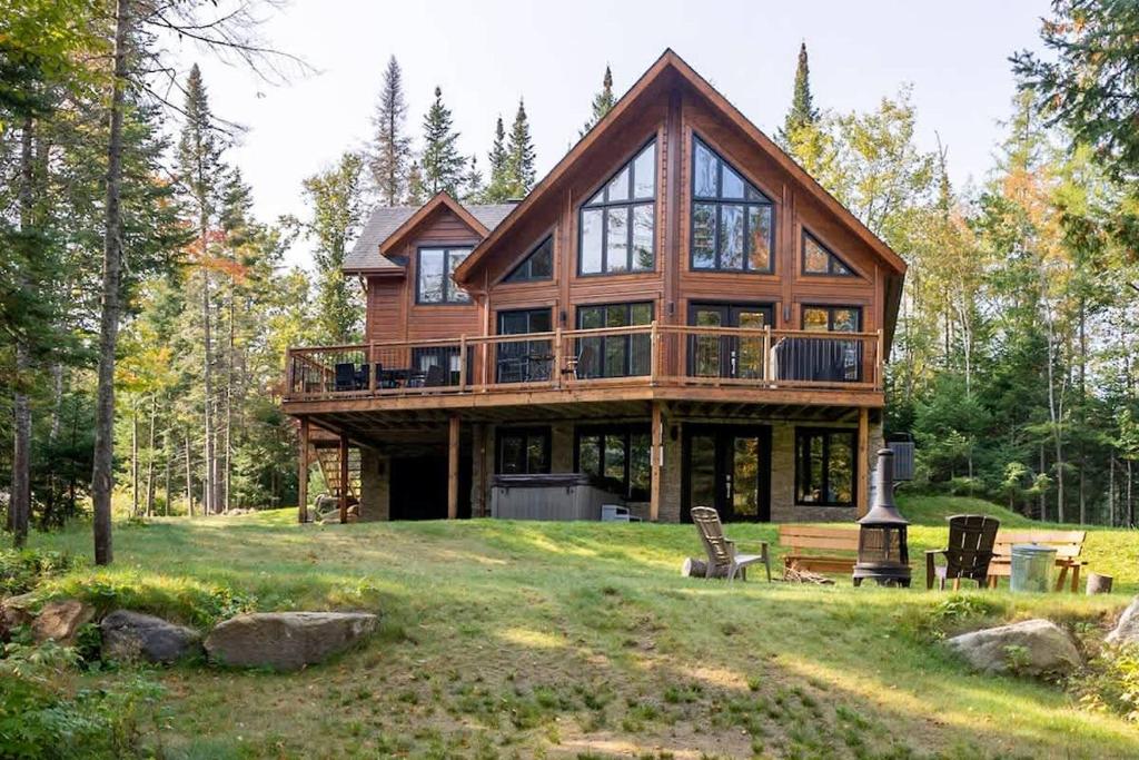 a large wooden house on a hill in the forest at Chinook 172 in Sainte-Marguerite
