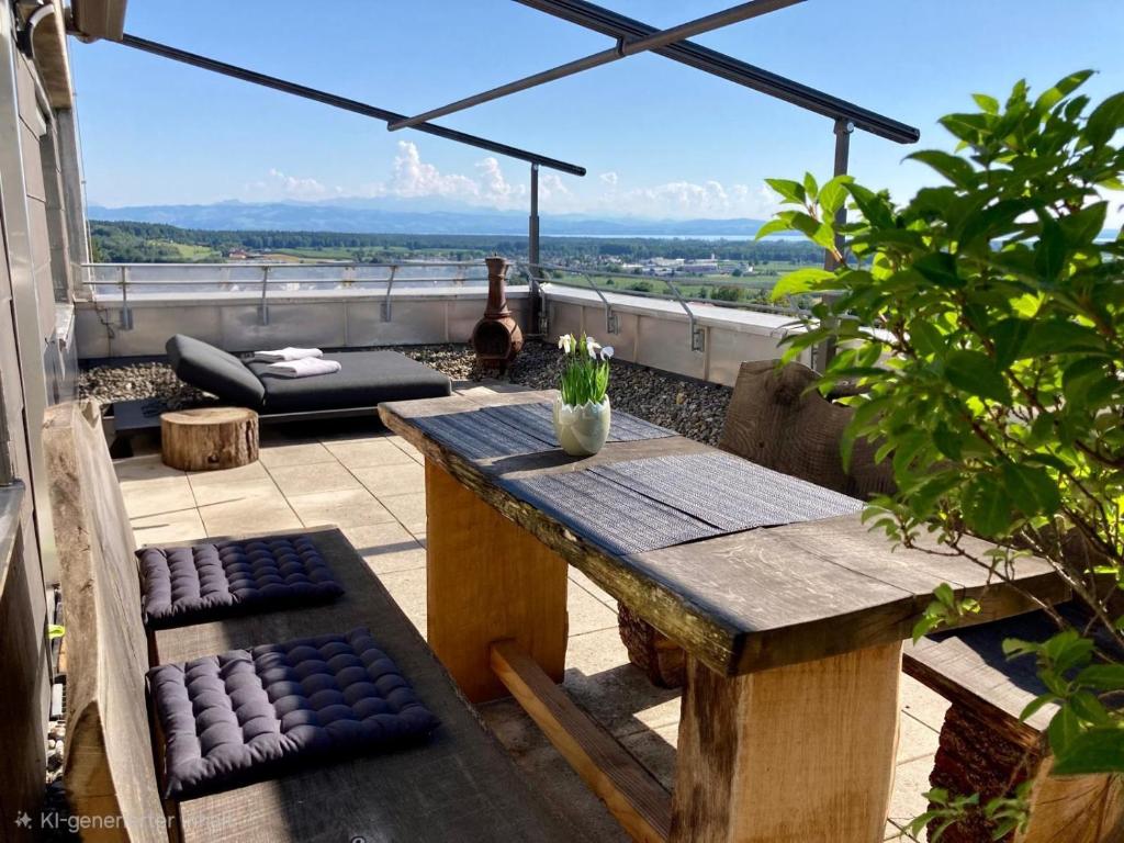 a wooden table and bench on a balcony with a view at Dmon-Home in Tettnang