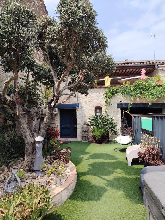 a yard with green grass and trees and a house at VILLA ARTEMIA - chambre d hôtes labellisée massages-piscine-climatisation in Sigean
