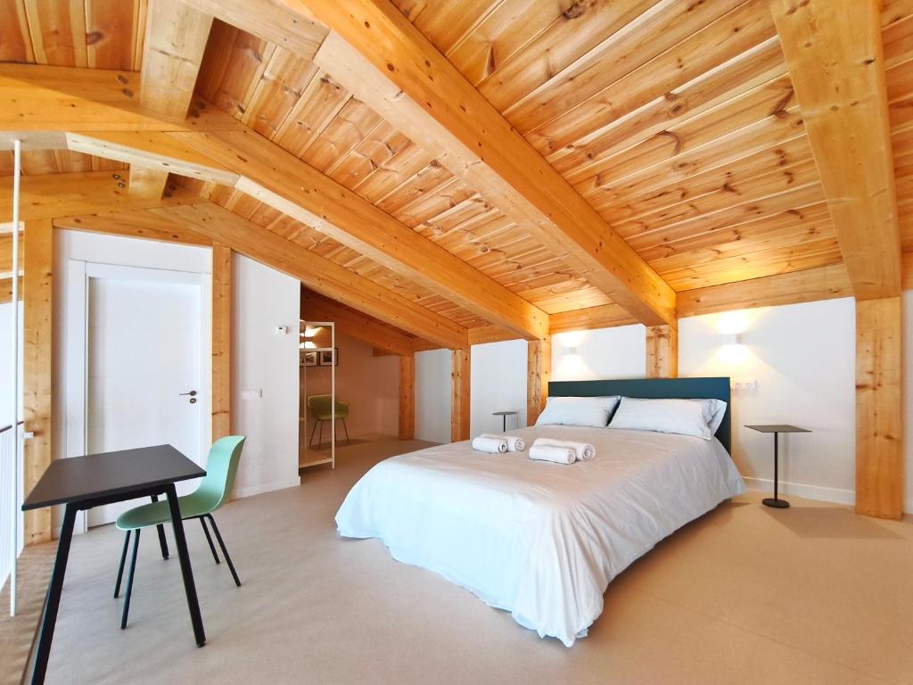 a bedroom with a large bed and a wooden ceiling at Apartamentos Mantería Lacort, Valladolid in Valladolid